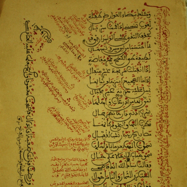 An ancient manuscript from Mauretaniens Manuskripten features Arabic text in elegant calligraphy, with some annotations in red ink.